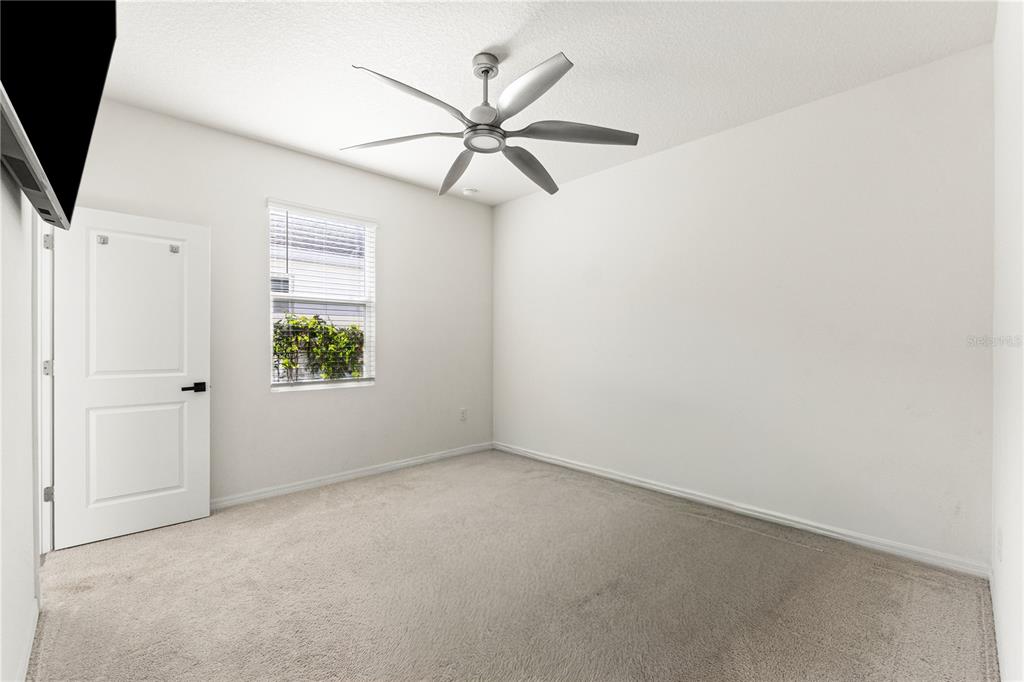 A bedroom with a bed, two mirrored nightstands, a television, and a window with blinds — 3763 AUTUMN AMBER DRIVE, SPRING HILL, FL