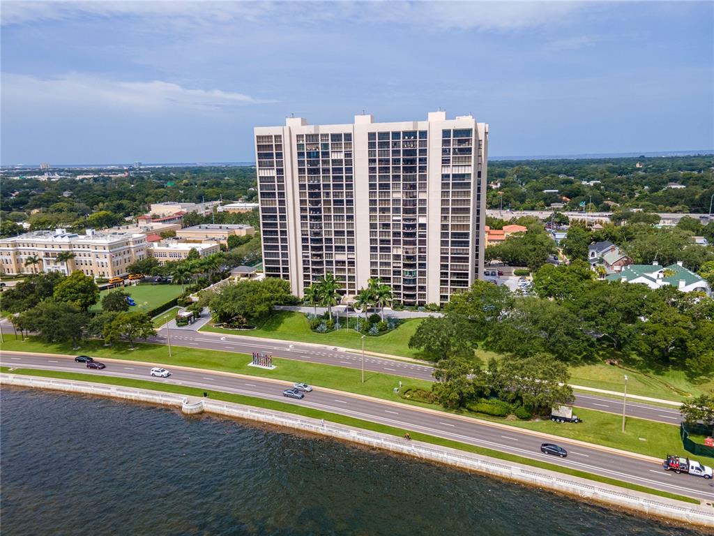 An aerial view shows a tall residential building situated along a waterfront road — 3301 BAYSHORE BOULEVARD UNIT 302E, TAMPA, FL