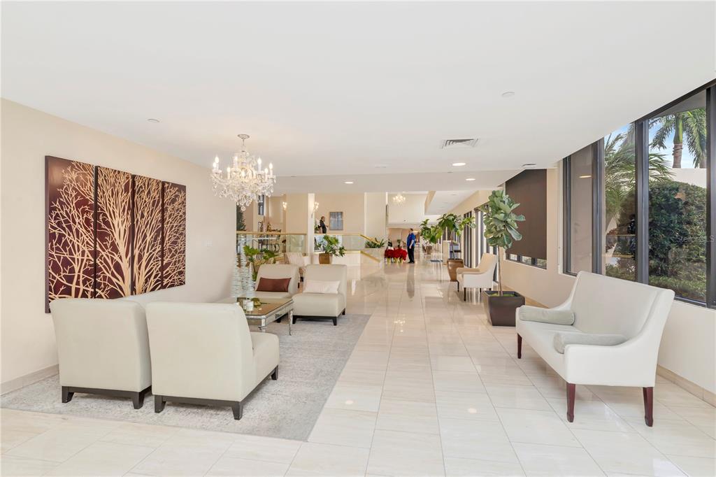 A bright, tiled lobby features a seating area, a crystal chandelier, and large windows — 3301 BAYSHORE BOULEVARD UNIT 302E, TAMPA, FL
