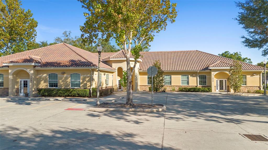 A single-story commercial building with a tile roof and a paved parking lot in front — 330 HARBOUR ISLE WAY UNIT 1020, LONGWOOD, FL