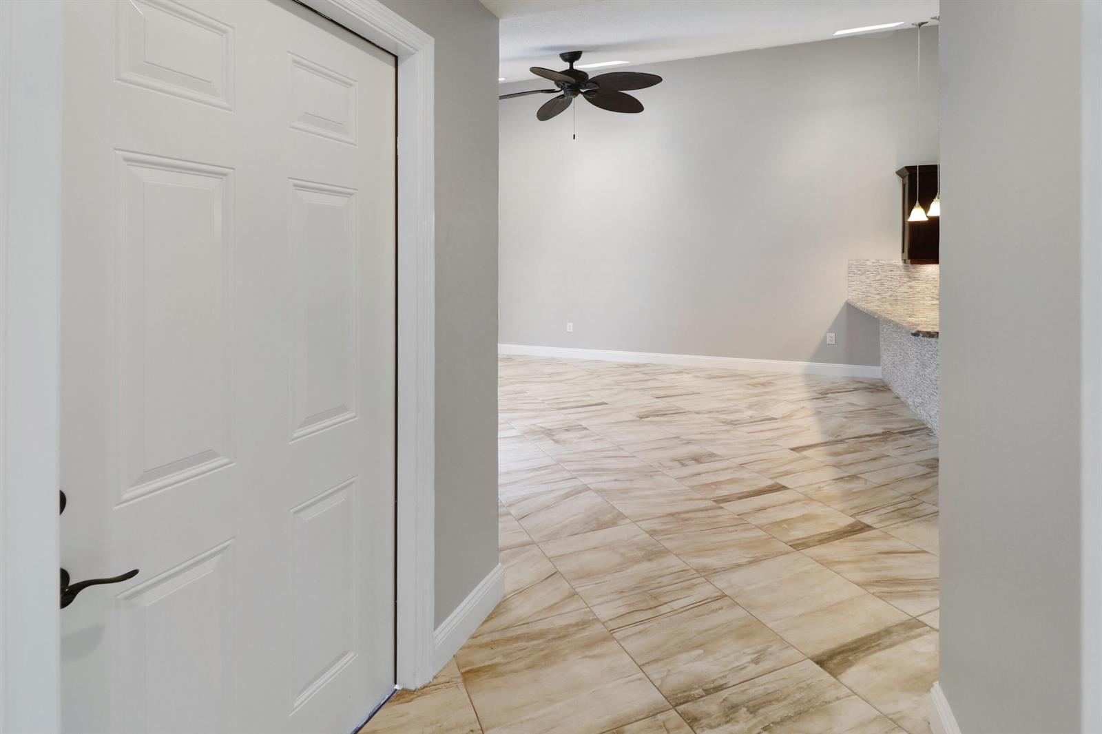 A view from a doorway into a room with light-colored tile floors and a ceiling fan — 9713 Boca Gardens Parkway # D, Boca Raton FL 33496, BOCA RATON, FL