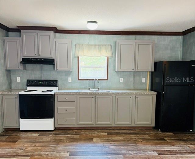 A kitchen features gray cabinets, a black refrigerator, a white stove, and wood-look flooring — 877 SE 38 WAY, MELROSE, FL