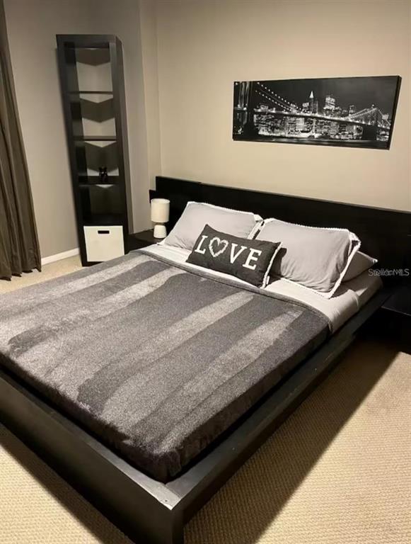 A bedroom features a black platform bed, a tall shelving unit, and a city-themed wall art — 701 S MADISON AVENUE UNIT 422, CLEARWATER, FL
