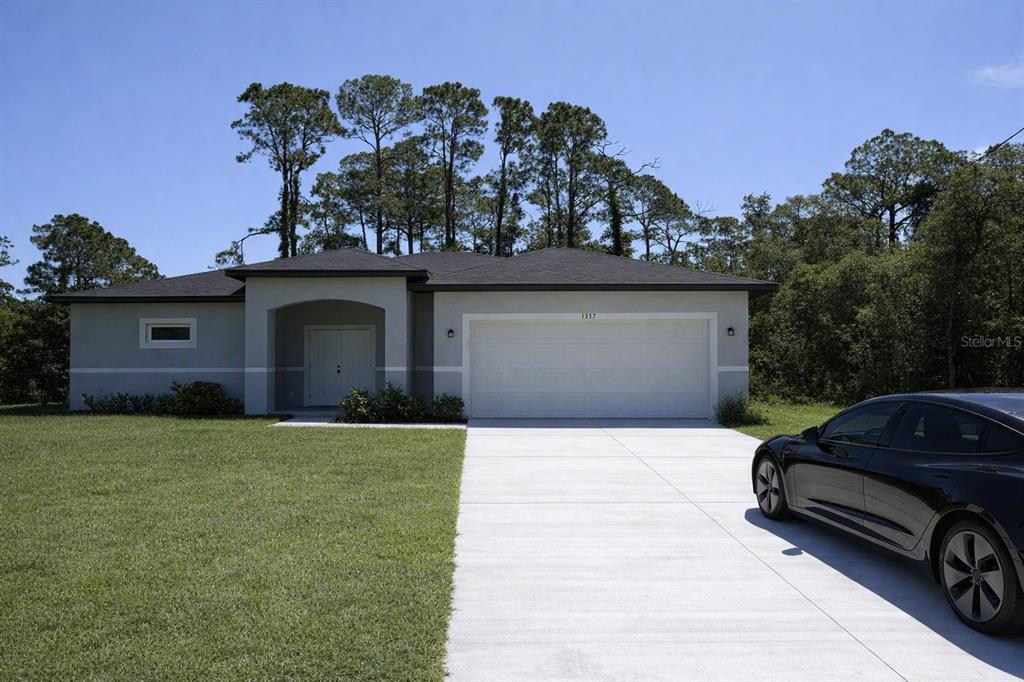 A single-story house with a two-car garage and a black car in the driveway — 1392 ALABELLE LANE, NORTH PORT, FL