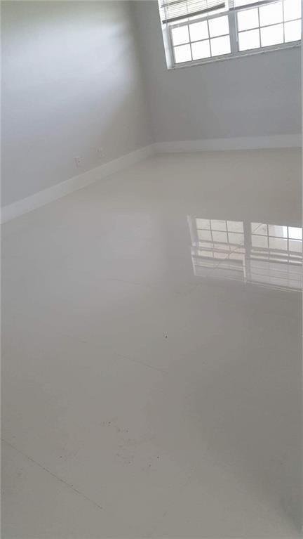 An empty room features white walls, a window with blinds, and glossy white tile flooring — 3150 N Course Lane # 607, Pompano Beach FL 33069, POMPANO BEACH, FL