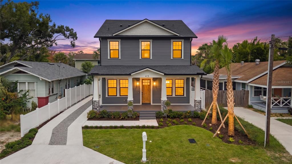 A two-story gray house with a front porch, stone pillars, and a gravel driveway — 413 W PARIS STREET, TAMPA, FL
