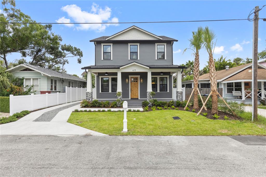 A two-story gray house with a front porch, stone pillars, and a wooden front door — 413 W PARIS STREET, TAMPA, FL
