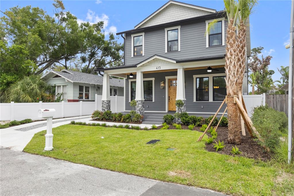 A two-story gray house with a front porch, stone columns, and a palm tree — 413 W PARIS STREET, TAMPA, FL