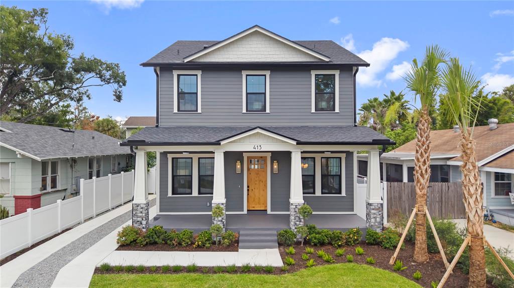 A two-story gray house with a front porch, stone pillars, and a wooden front door — 413 W PARIS STREET, TAMPA, FL