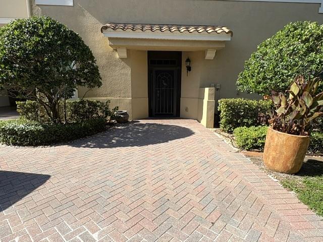 A paved walkway leads to the front entrance of a house with a covered porch — 1425 EMERALD DUNES DRIVE UNIT 17, SUN CITY CENTER, FL