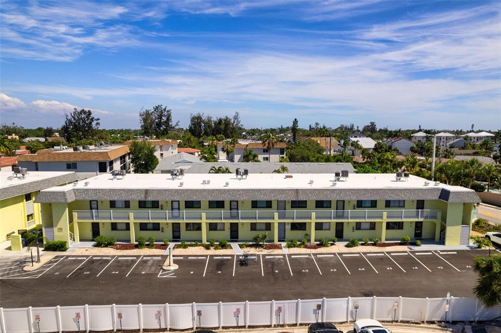 An exterior view of a two-story apartment building with a parking lot in front — 6703 MIDNIGHT PASS ROAD UNIT 101, SARASOTA, FL