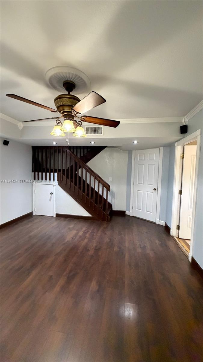 A room with dark wood flooring, a ceiling fan, and a wooden staircase — 2450 W 67th Pl # 12, Hialeah FL 33016, HIALEAH, FL