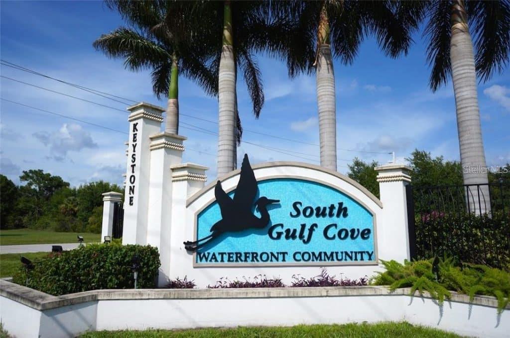A stone entrance sign for South Gulf Cove Waterfront Community stands beneath several palm trees — 13958 ALLAMANDA CIRCLE, PORT CHARLOTTE, FL