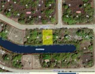 This is an aerial map showing a highlighted vacant residential lot bordering a small pond — 13958 ALLAMANDA CIRCLE, PORT CHARLOTTE, FL