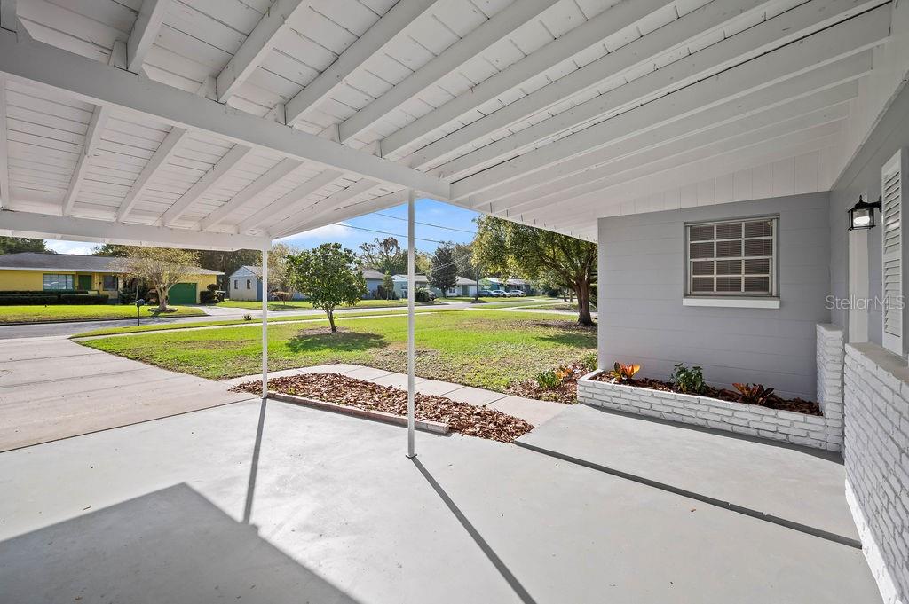 A covered concrete carport with a white ceiling and a small brick planter box — 600 VENTURA AVENUE, ORLANDO, FL