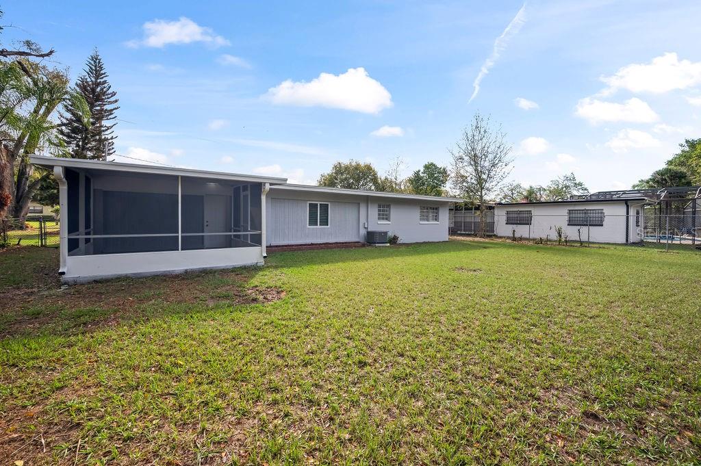 The backyard features a gray house with a screened-in porch and a detached garage — 600 VENTURA AVENUE, ORLANDO, FL