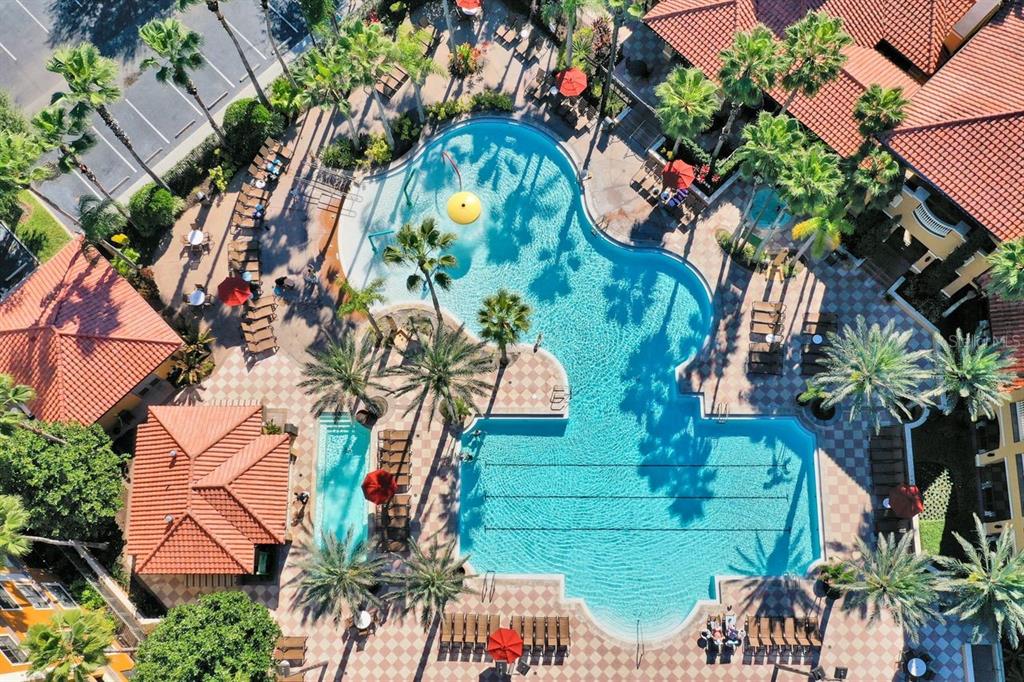 An aerial view shows a resort-style swimming pool with palm trees and lounge chairs — 12556 FLORIDAYS RESORT DRIVE UNIT A-307, ORLANDO, FL