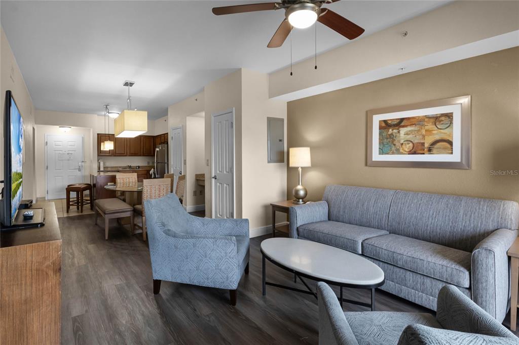 A living room with a grey sofa, two armchairs, a coffee table, and an open kitchen — 12556 FLORIDAYS RESORT DRIVE UNIT A-307, ORLANDO, FL
