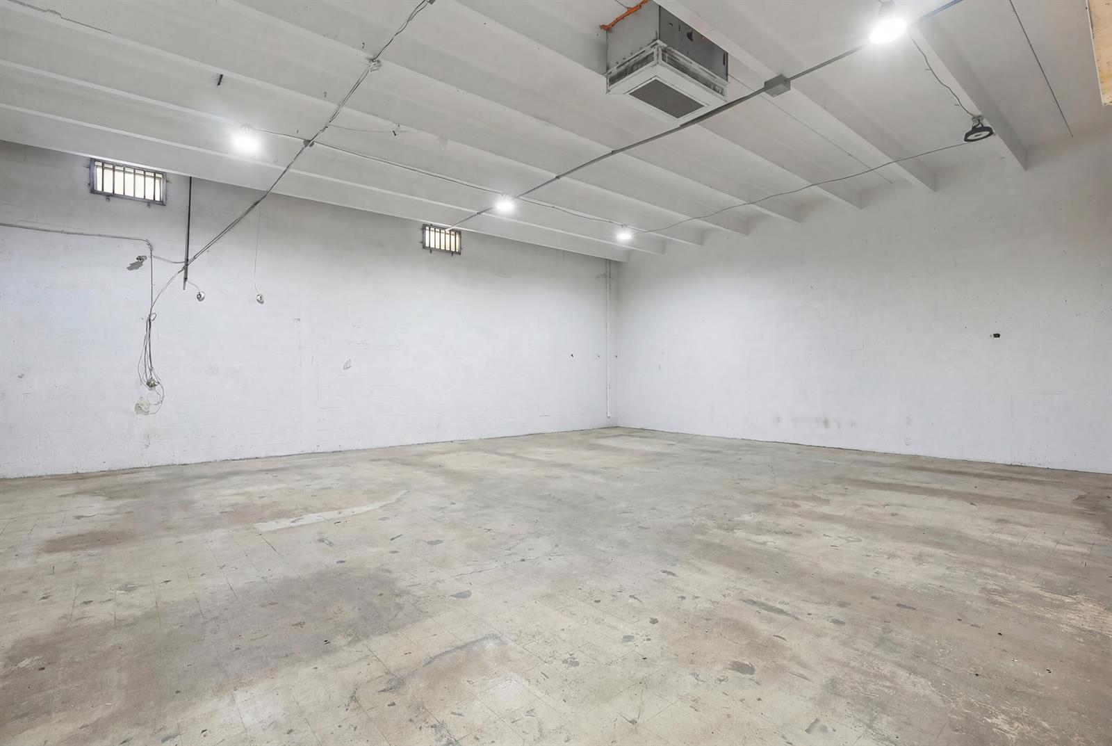 An empty industrial room with white walls, a concrete floor, and exposed ceiling beams — 1800 N Dixie Highway, Hollywood FL 33020, HOLLYWOOD, FL