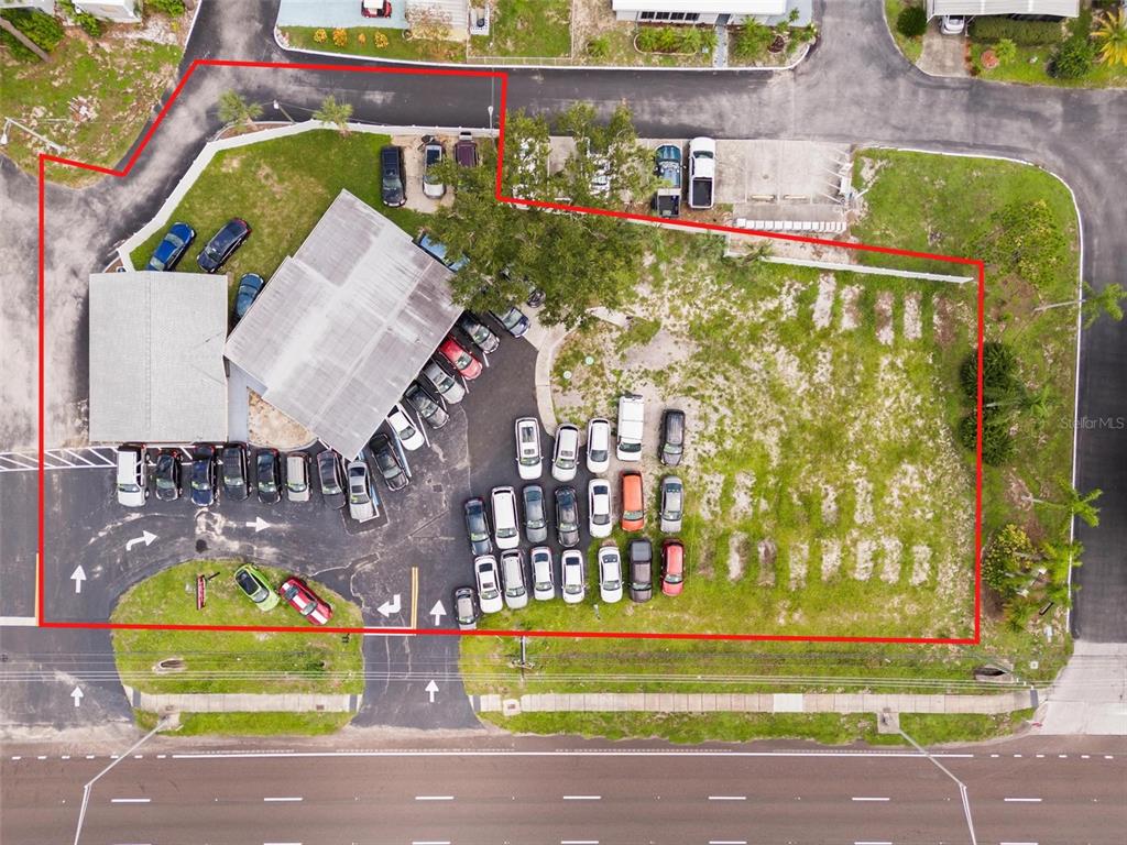 An aerial view shows a commercial property with a building, parking lot, and many cars — 38795 US HIGHWAY 19 N, TARPON SPRINGS, FL