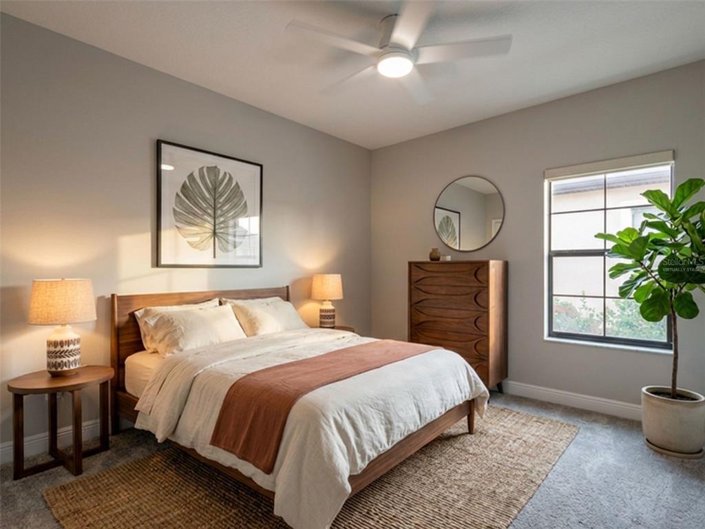 A bedroom features a wooden bed frame, a dresser with a mirror, and a ceiling fan — 13419 HEARTWOOD WAY, PARRISH, FL