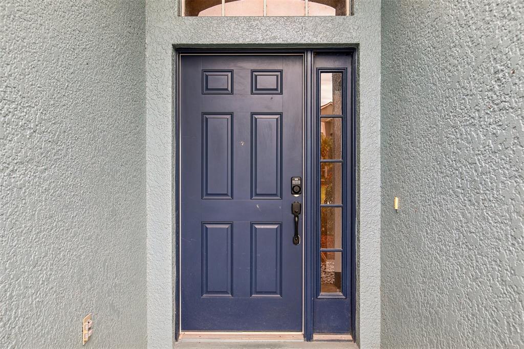 A dark blue front door with a side window and a digital keypad lock — 2700 SIERRA VISTA WAY, HOLIDAY, FL