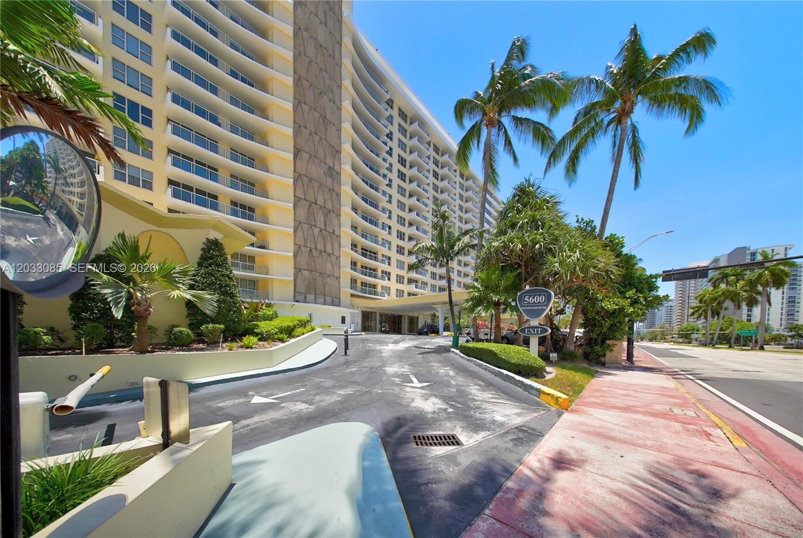 A multi-story residential building with a curved facade and a driveway entrance — 5600 Collins Ave # 7W, Miami Beach FL 33140, MIAMI BEACH, FL