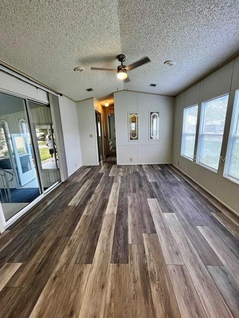 A sunroom features wood-look plank flooring, a ceiling fan, and large windows — 50989 HIGHWAY 27 UNIT 128, DAVENPORT, FL