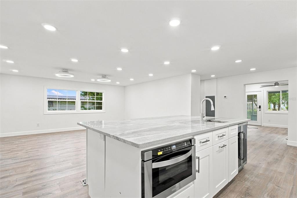 A kitchen island with a microwave and sink sits in a room with white walls — 163 DOLPHIN DRIVE E, OLDSMAR, FL