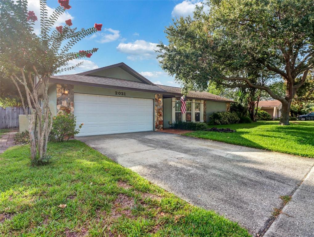 A single-story house with a two-car garage, stone accents, and a concrete driveway — 2021 TODD ROAD, CLEARWATER, FL