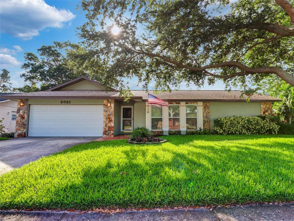 A single-story house with a white garage door, stone accents, and a green lawn — 2021 TODD ROAD, CLEARWATER, FL