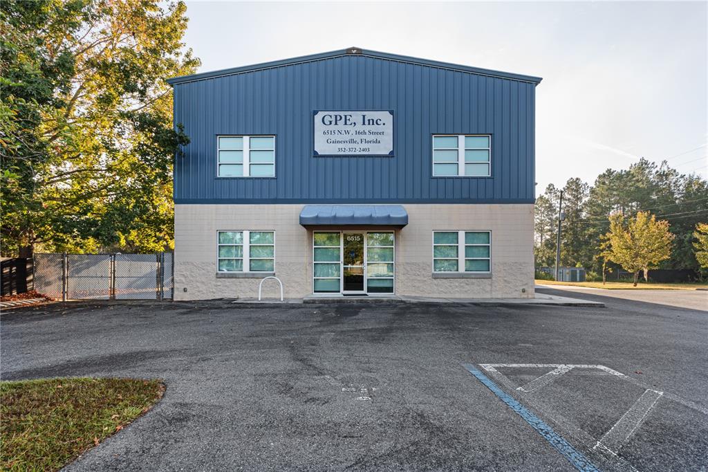 A two-story commercial building with blue metal siding and a beige concrete block base — 6515 NW 16TH STREET, GAINESVILLE, FL