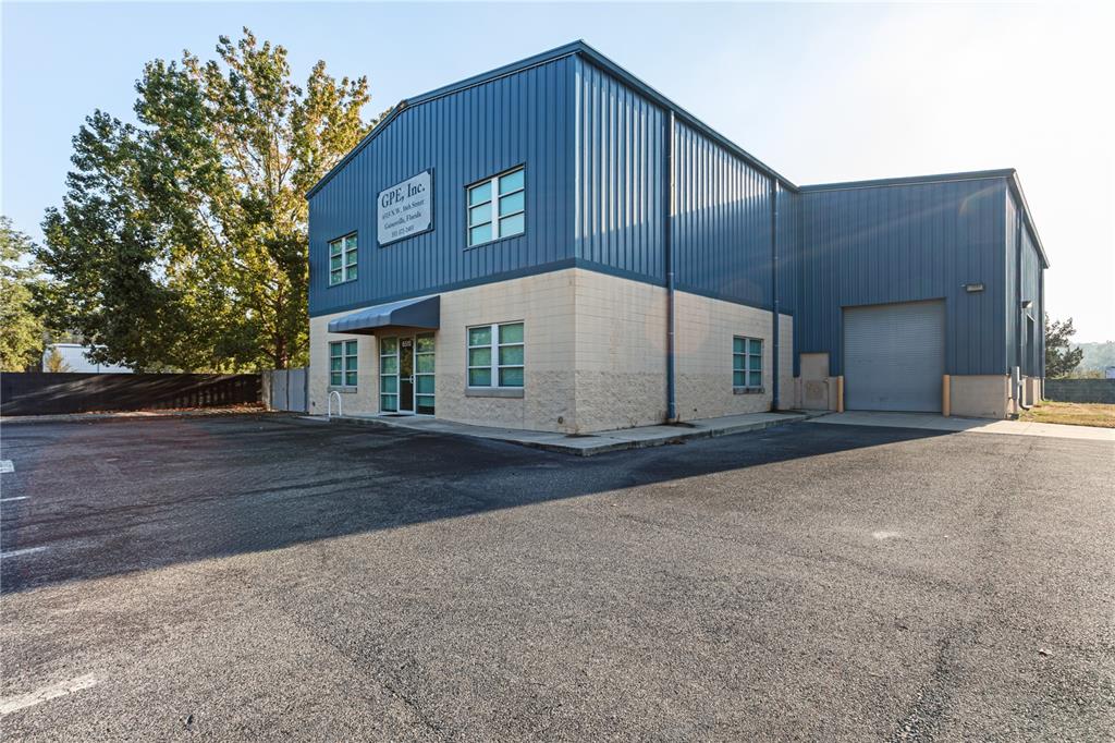 A two-story commercial building with blue metal siding and a tan concrete block base — 6515 NW 16TH STREET, GAINESVILLE, FL