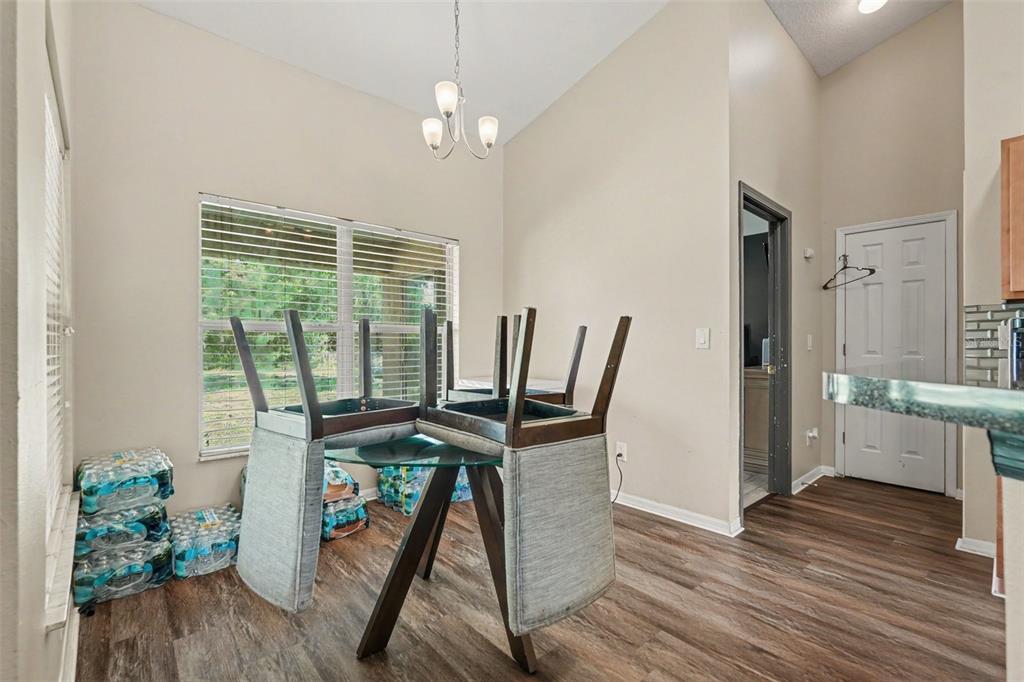 A dining area features a glass-topped table with chairs placed upside down on top — 11222 MONTCALM ROAD, SPRING HILL, FL