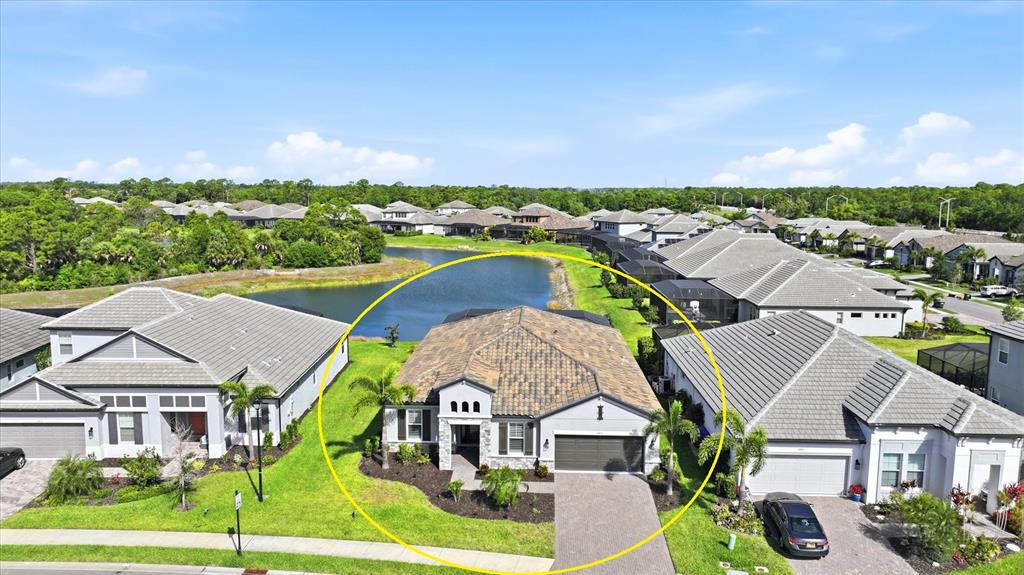 An aerial view shows a single-story house with a tiled roof and a paved driveway — 19857 MONTENERO WAY, VENICE, FL