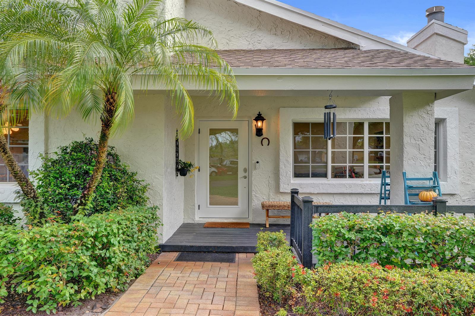 A white stucco house exterior features a brick walkway, a covered porch, and a palm tree — 12213 Melissa Way, Cooper City FL 33026, COOPER CITY, FL