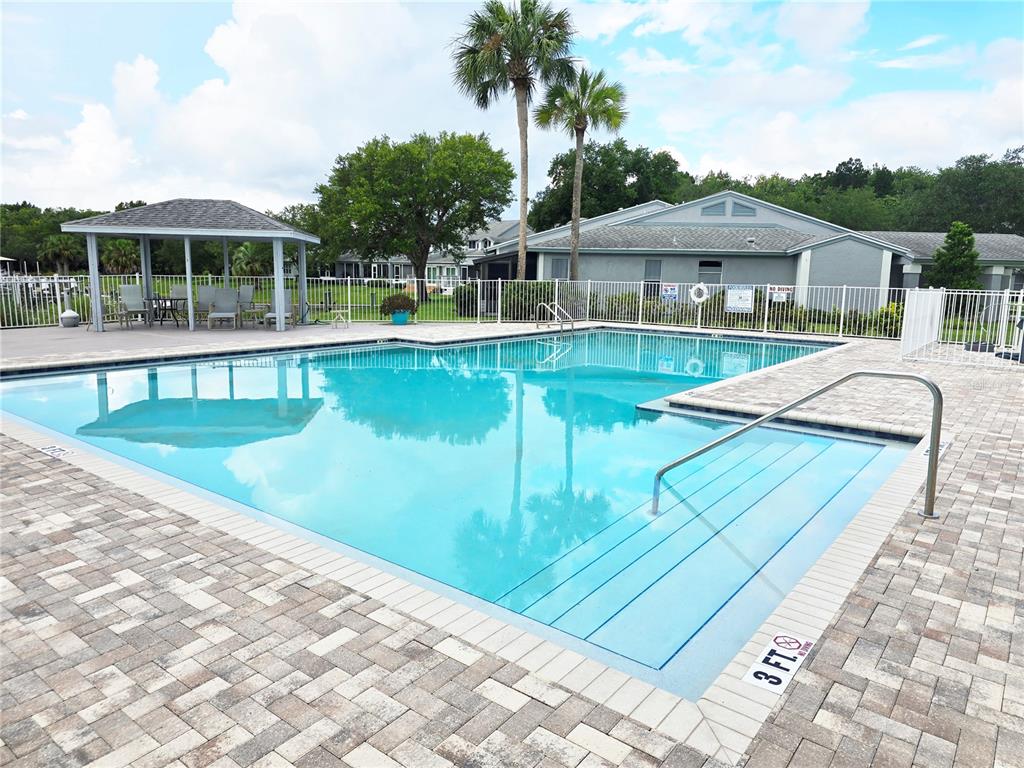 A rectangular outdoor swimming pool features a shallow entry area with steps and a gazebo — 10906 W COVE HARBOR DRIVE UNIT 10906, CRYSTAL RIVER, FL