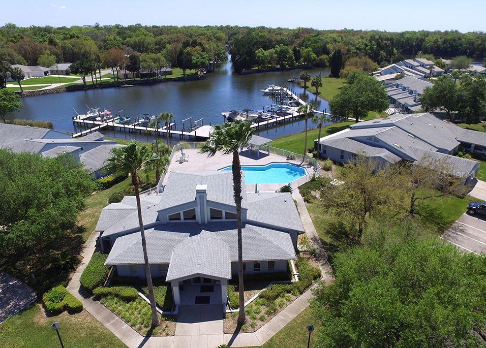 An aerial view shows a clubhouse with a swimming pool, boat docks, and surrounding buildings — 10906 W COVE HARBOR DRIVE UNIT 10906, CRYSTAL RIVER, FL