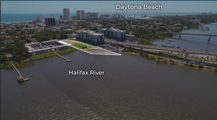 An aerial view of a waterfront vacant lot highlighted in white along the Halifax River — 613 HALIFAX AVENUE, DAYTONA BEACH, FL