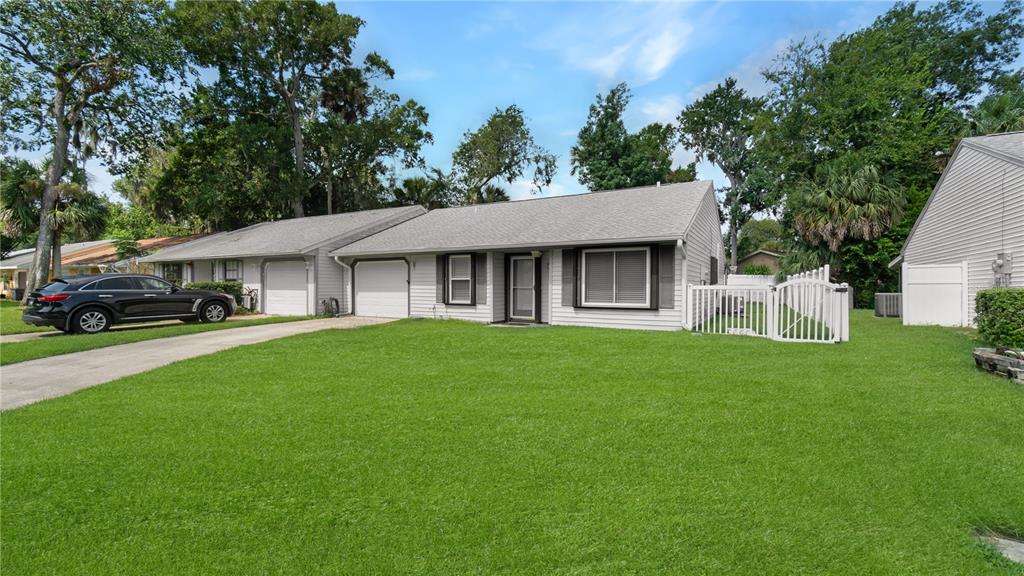 A single-story house with light gray siding, a garage, and a large front lawn — 3744 GATEWOOD DRIVE, PORT ORANGE, FL