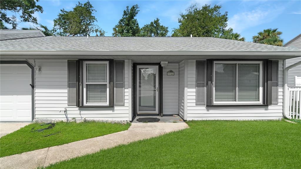 A single-story house with light gray horizontal siding, a front door, and two windows — 3744 GATEWOOD DRIVE, PORT ORANGE, FL