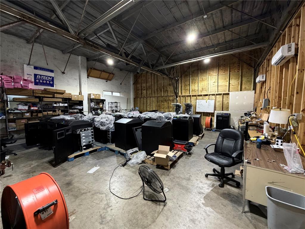 A large industrial warehouse space features exposed wooden framing, concrete floors, and multiple black equipment units — 4320 S MANHATTAN AVENUE, TAMPA, FL