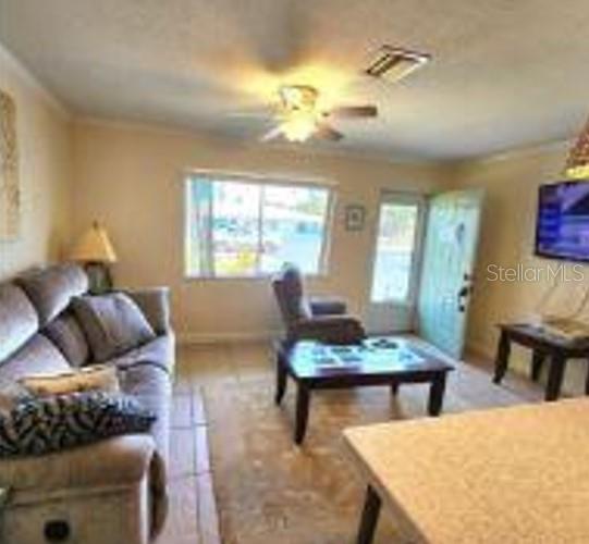 A living room features a sofa, a coffee table, a recliner, and a ceiling fan — 525 MANATEE COURT UNIT 13, VENICE, FL