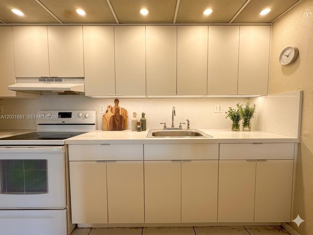 A kitchen features white flat-panel cabinets, a white countertop, a stainless steel sink, and appliances — 17650 NW 68th Ave # A2005, Hialeah FL 33015, HIALEAH, FL