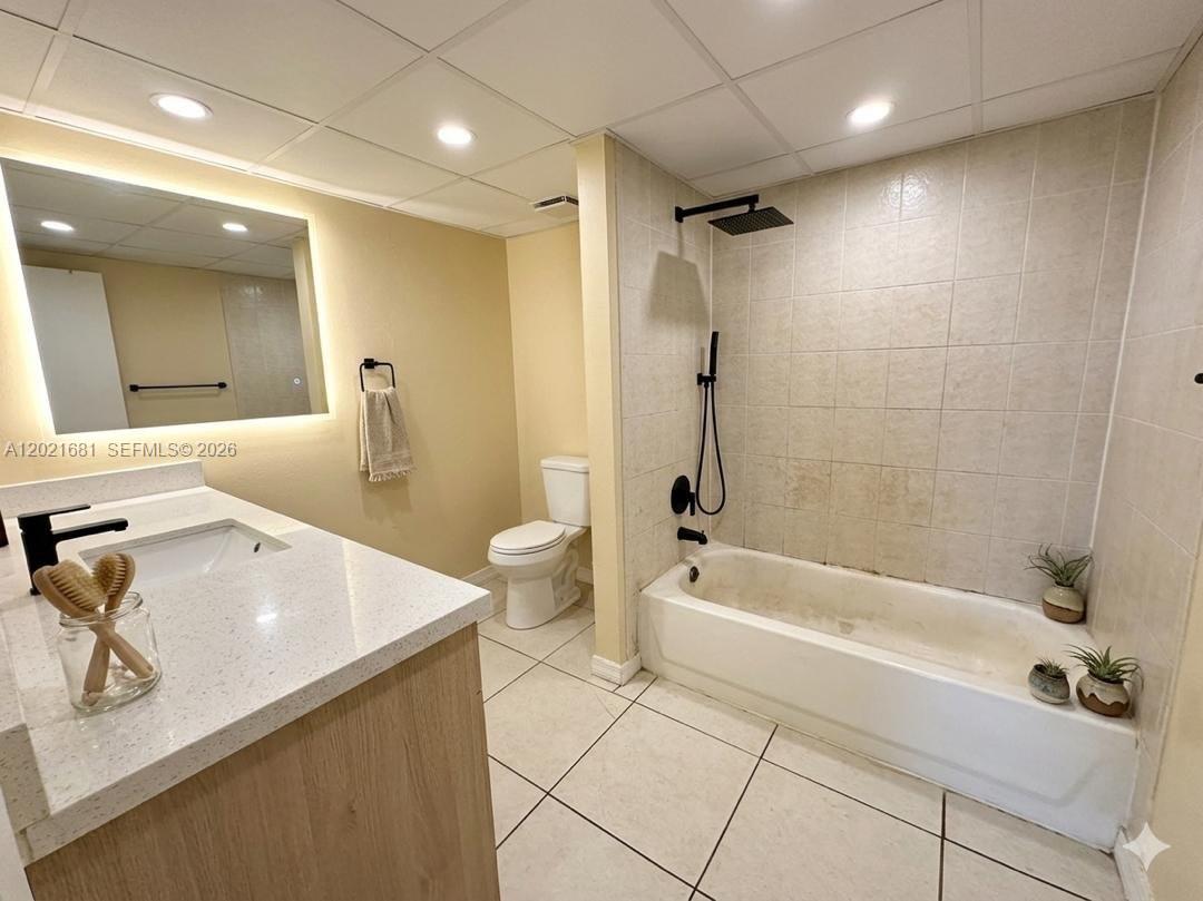 A bathroom features a vanity with a white countertop, a toilet, and a tiled tub-shower — 17650 NW 68th Ave # A2005, Hialeah FL 33015, HIALEAH, FL