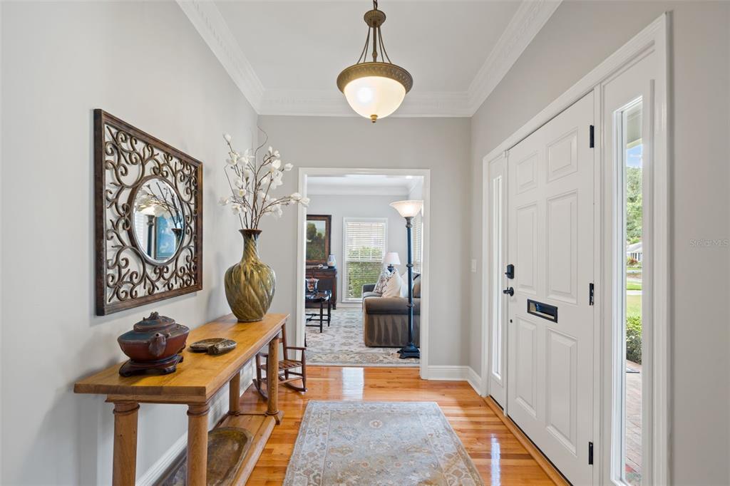 A covered front porch features a blue door, gray shingle siding, and a small bistro set — 3233 W PARKLAND BOULEVARD, TAMPA, FL