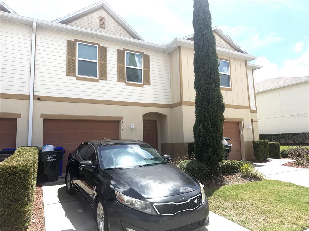 A two-story townhouse exterior features a black car parked in the driveway — 3843 EXETER LANE, LAKELAND, FL