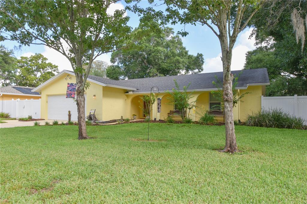 A yellow single-story house with a two-car garage and arched entryway sits on a lawn — 433 CENTER STREET, ALTAMONTE SPRINGS, FL