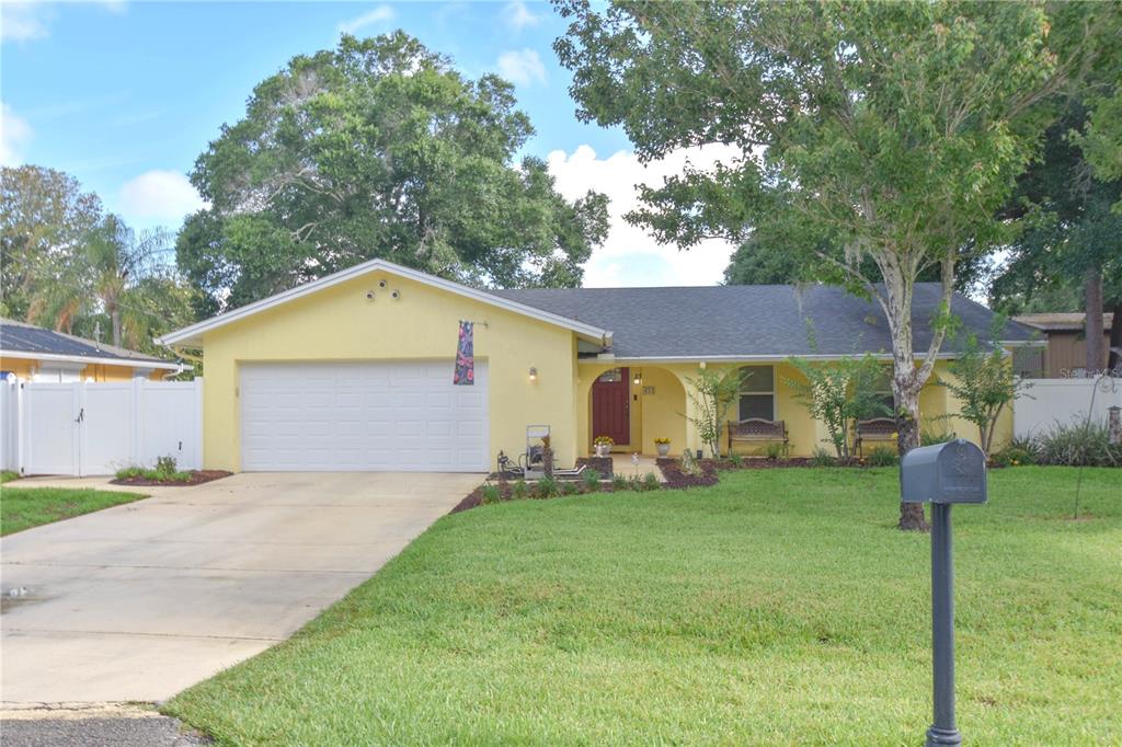 A yellow single-story house with a two-car garage, a red front door, and a lawn — 433 CENTER STREET, ALTAMONTE SPRINGS, FL