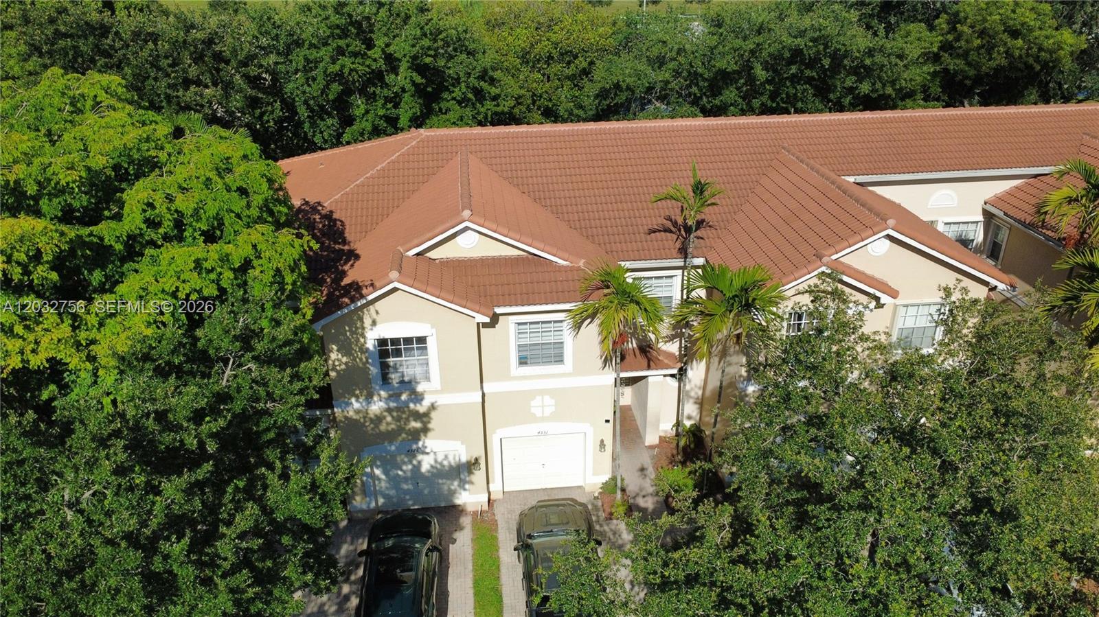 An aerial view shows a two-story beige townhouse with a brown tile roof and garages — 4331 SW 124th Way, Miramar FL 33027, MIRAMAR, FL